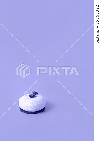 One mousse pastry dessert covered with white chocolate and decorated with rose buds toned in trendy color of year 2022. Modern stylish cake. Copy space. Close-up. One mousse pastry dessert covered with white chocolate and decorated with rose buds toned in trendy color of year 2022. Modern stylish cake. Copy space. Close-up. 85668322