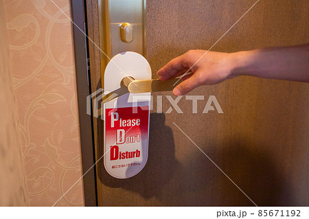 「Don't disturb」がかけられた部屋に入ろうとする様子 85671192