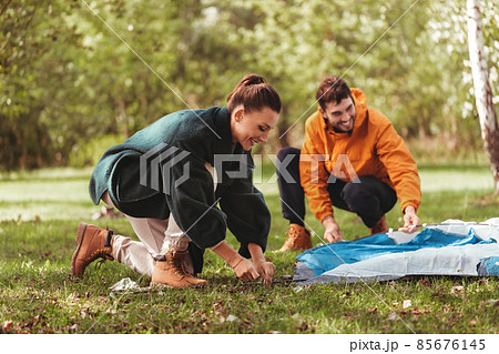 happy couple setting up tent outdoors 85676145