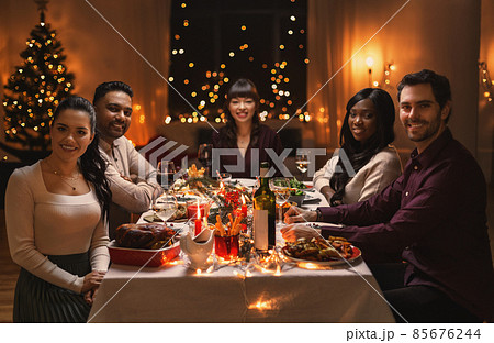 happy friends having christmas dinner at home happy friends having christmas dinner at home 85676244