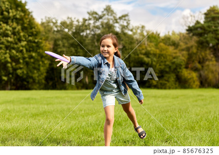 happy girl playing with flying disc at park happy girl playing with flying disc at park 85676325