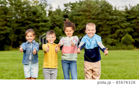 happy children showing thumbs up at park happy children showing thumbs up at park 85676326