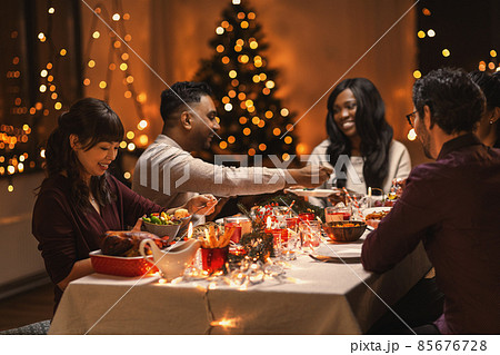 happy friends having christmas dinner at home 85676728