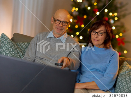 senior couple watching tv at home on christmas senior couple watching tv at home on christmas 85676853