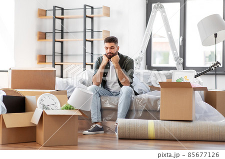 sad man with boxes moving to new home 85677126