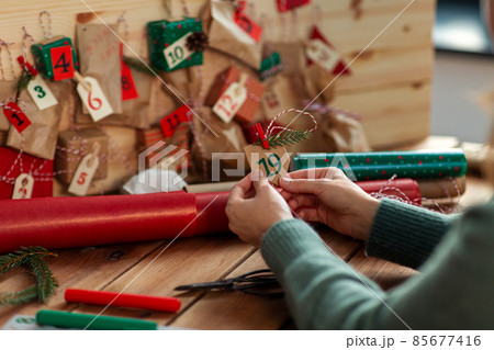 woman making advent calendar on christmas at home woman making advent calendar on christmas at home 85677416