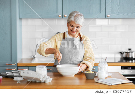 happy woman cooking food on kitchen at home 85677417