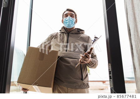 delivery man in mask with parcel box and clipboard 85677481