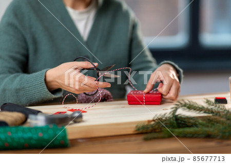 close up of woman packing christmas gift at home 85677713
