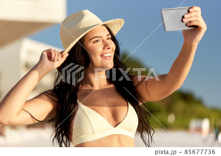 smiling woman in bikini taking selfie on beach smiling woman in bikini taking selfie on beach 85677736