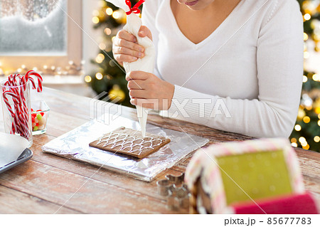 close up of woman making gingerbread house close up of woman making gingerbread house 85677783
