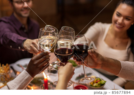 happy friends drinking wine at christmas party 85677894