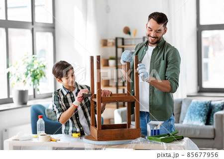 father and son sanding old table with sponge 85677956