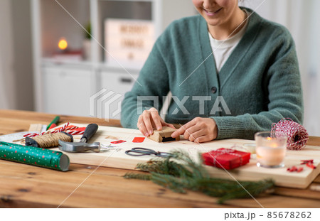 close up of woman packing christmas gift at home 85678262