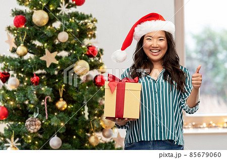 happy woman with christmas gift showing thumbs up happy woman with christmas gift showing thumbs up 85679060