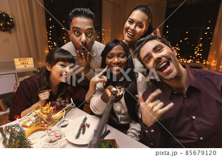friends taking selfie on christmas dinner at home friends taking selfie on christmas dinner at home 85679120