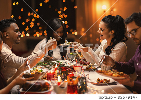 happy friends having christmas dinner at home happy friends having christmas dinner at home 85679147
