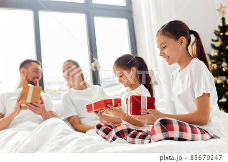 happy family with christmas gifts in bed at home happy family with christmas gifts in bed at home 85679247