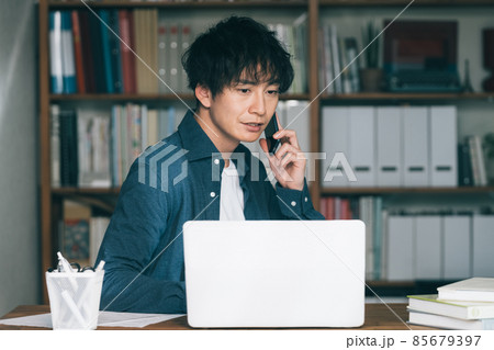 仕事場でスマホ通話する男性 仕事場でスマホ通話する男性 85679397