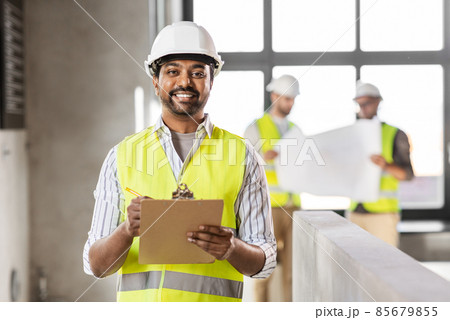male architect in helmet with clipboard at office 85679855