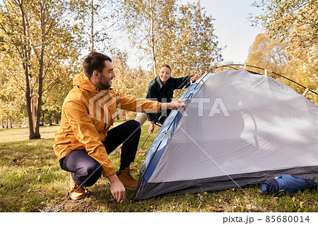 happy couple setting up tent outdoors 85680014