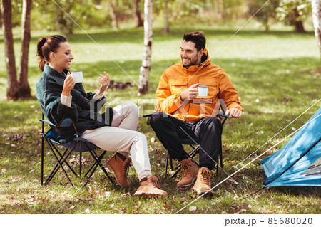 happy couple drinking tea at tent camp happy couple drinking tea at tent camp 85680020