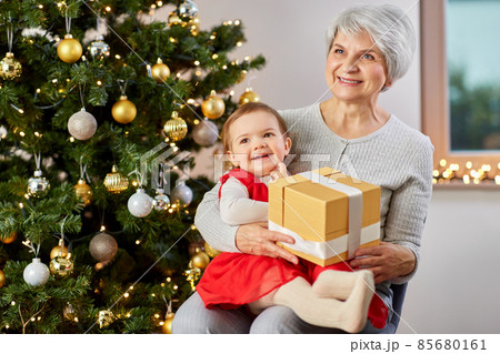 grandmother and baby girl with christmas gift grandmother and baby girl with christmas gift 85680161