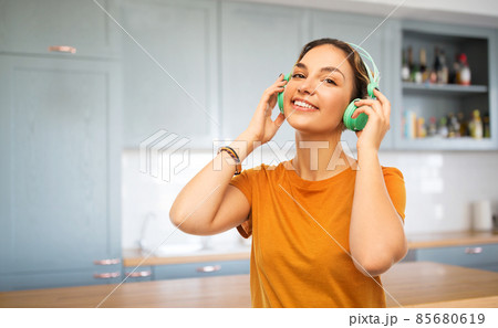 happy young woman with headphones at kitchen 85680619