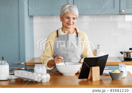 happy woman with cook book cooking food on kitchen happy woman with cook book cooking food on kitchen 85681210