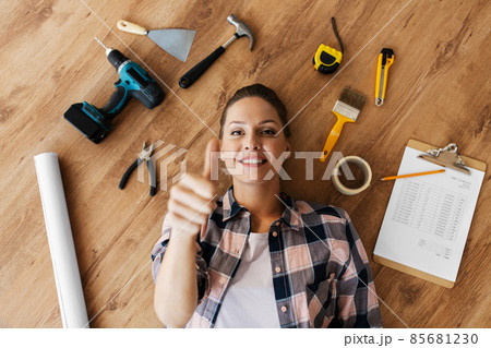 woman with working tools lying on wooden floor woman with working tools lying on wooden floor 85681230