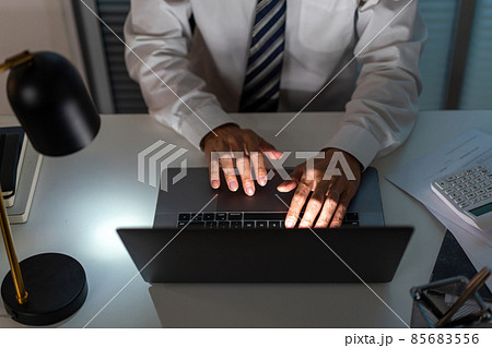 Overwork Concept The man sitting at his desk and focusing on working through his computer laptop Overwork Concept The man sitting at his desk and focusing on working through his computer laptop 85683556