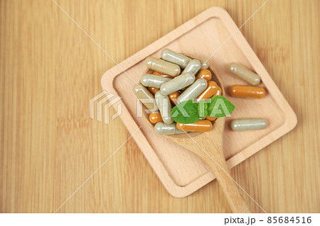 Herbal medicine in capsules from moringa leaf on rustic wooden table with copy space for medical background, healthy eating with natural product for good living 85684516