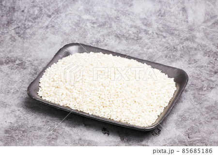 Tray with white rice grains on a gray stone background. Healthy food Tray with white rice grains on a gray stone background. Healthy food 85685186