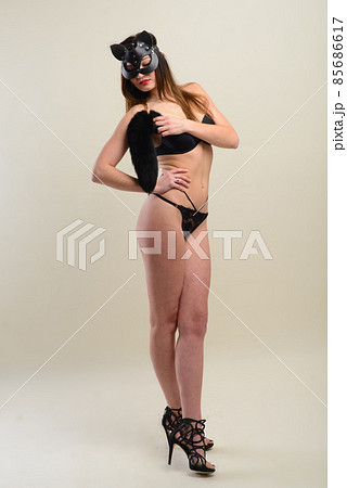 Young caucasian female in black underwear wearing a cat mask. 85686617