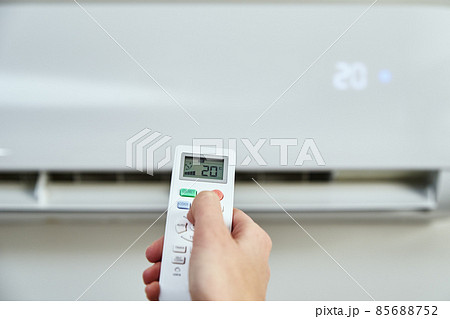 Hand adjusting temperature on air conditioner Hand adjusting temperature on air conditioner 85688752