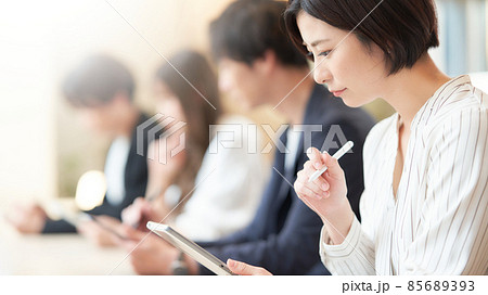 手にしたタブレットに筆記する若い女性 手にしたタブレットに筆記する若い女性 85689393