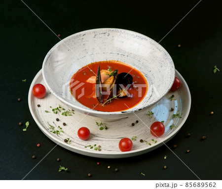 Fish soup, norman fish soup bouillabaisse with seafood in a plate on a black background 85689562