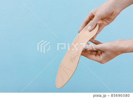 Orthopedic insole isolated on a blue background. Medical insoles. Treatment and prevention of flat feet and foot diseases. Foot care, feet comfort. Wear comfortable shoes. Flat Feet Correction. Orthopedic insole isolated on a blue background. Medical insoles. Treatment and prevention of flat feet and foot diseases. Foot care, feet comfort. Wear comfortable shoes. Flat Feet Correction. 85690380