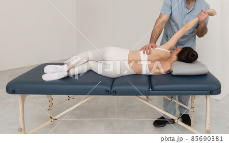 Back massage. Chiropractor or osteopath fixing back during visit in manual therapy clinic. Doctor doing shoulder blade therapy. Scoliosis. Posture Correction. Chiropractic treatment, Back pain relief. 85690381