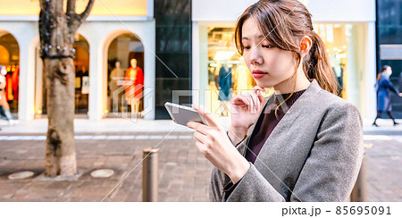 東京丸の内でスマホで地図を確認する若いビジネスウーマン 85695091