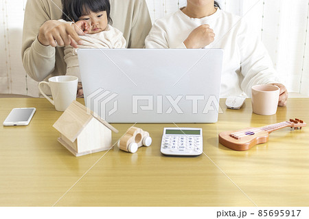 ノートパソコンを使って生活設計をする家族のイメージ 85695917