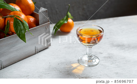 A shot with tangerine liqueur on a white wooden table 85696707
