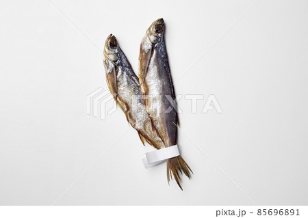 Two jerked or dried salted sabrefish with paper labels on tails isolated on white 85696891