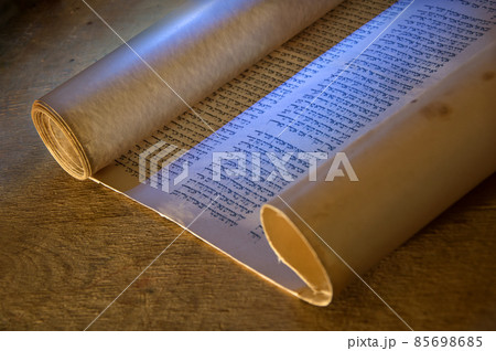 Ancient scroll lit by candlelight Ancient scroll lit by candlelight 85698685