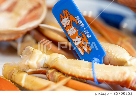 タグ付きの松葉ガニの足を取ってお皿に置いたところ 85700252