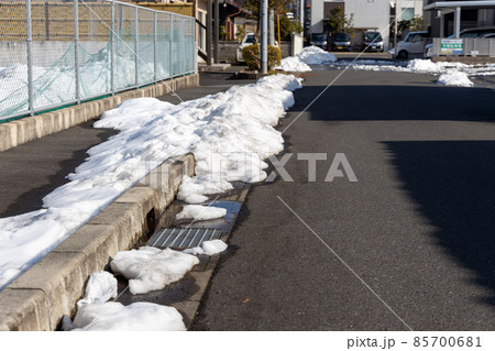 雪かきをした雪がまだ残っている道路 85700681