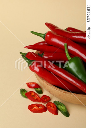 Bowl with red and green hot peppers on beige background Bowl with red and green hot peppers on beige background 85701634
