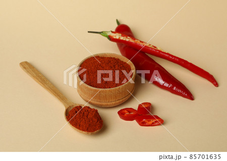 Red chili pepper and powder on beige background Red chili pepper and powder on beige background 85701635