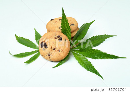 Cannabis leaves and cookies on white background Cannabis leaves and cookies on white background 85701704