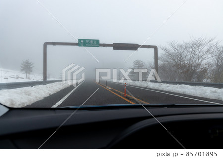道路わきに雪の積もった、霧の濃い京都縦貫道を走る自動車の助手席からの風景 道路わきに雪の積もった、霧の濃い京都縦貫道を走る自動車の助手席からの風景 85701895